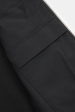 Close-up front view of Moose Knuckles Down Blouson 'Kamet Hybrid' black showing viscose microfiber fabric, knitted back and sleeves, soft touch, slim fit, robust two-way zipper, high closing ribbed collar, metal logo on upper arm, slanted hip pockets, lig