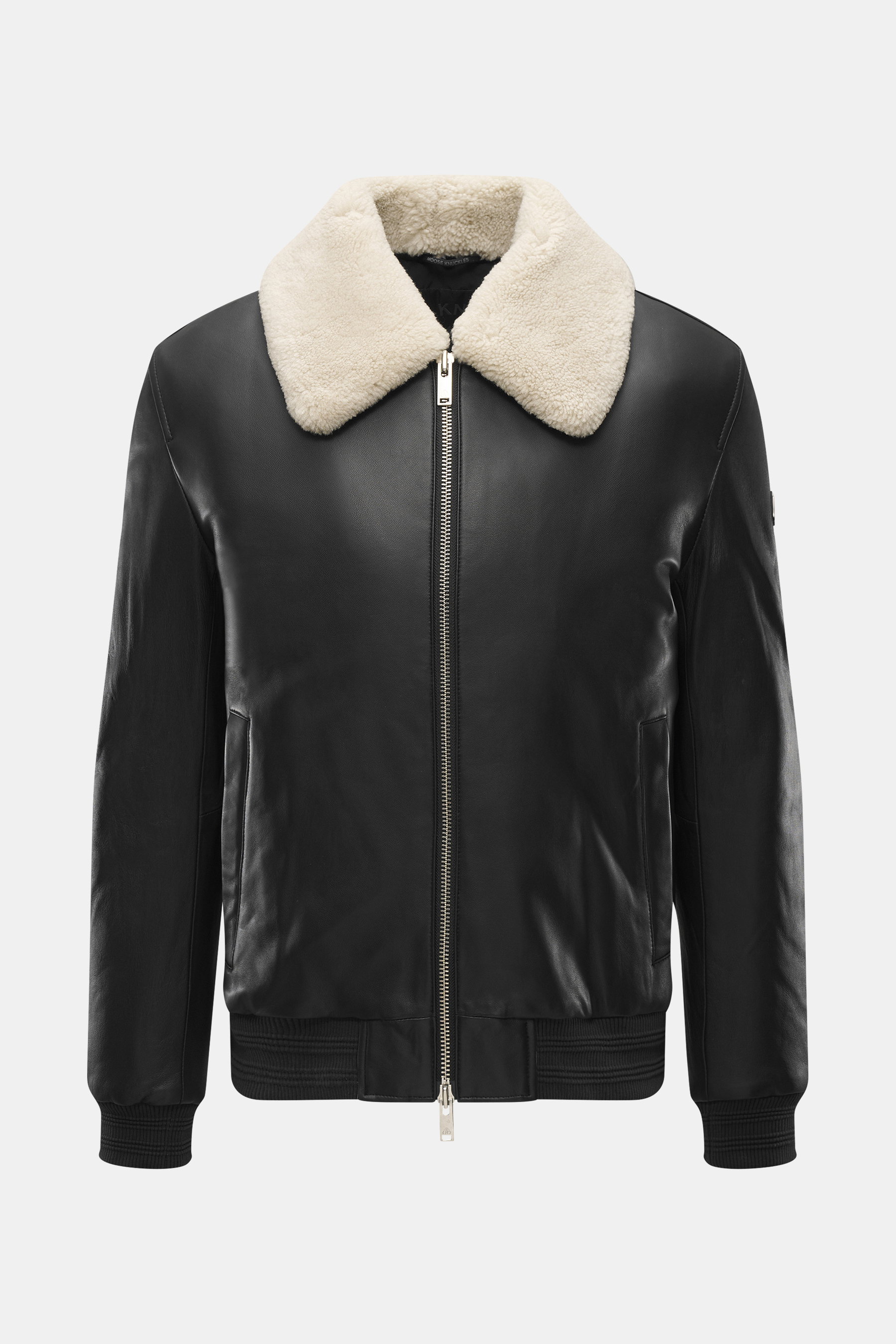 Front view of Moose Knuckles Leather blouson 'Toba Bomber' black with lambskin collar, slim fit, two-way zipper, and metal logo on upper arm.

Description: <p>Perfect for urban winter looks: The 'Toba Bomber' blouson from MOOSE KNUCKLES made of fine leath
