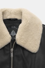 Close-up front view of Moose Knuckles Leather blouson 'Toba Bomber' black showing fine leather, lambskin collar trim, and metal zipper.

Description: 
<p>Perfect for urban winter looks: The 'Toba Bomber' blouson from MOOSE KNUCKLES made of fine leather wi