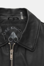 Moose Knuckles Leder-Blouson 'Toba Bomber' schwarz, Detailaufnahme von oben, edles Lammleder, glatter Griff, Metall-Logo, Lammfell-Kragen.