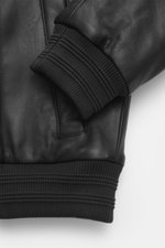 Close-up view of the sleeve cuff and pocket of the Moose Knuckles Leather blouson 'Toba Bomber' black, showcasing fine lamb leather and ribbed elastic details.

Description: <p>Perfect for urban winter looks: The 'Toba Bomber' blouson from MOOSE KNUCKLES 