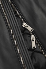 Close-up front view of the Moose Knuckles Leather blouson 'Toba Bomber' black zipper and textured leather surface. Perfect for urban winter looks: The 'Toba Bomber' blouson from MOOSE KNUCKLES made of fine leather with the brand-typical metal logo is a ve
