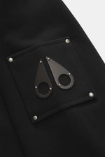 Close-up view of the sleeve of the Moose Knuckles Sweat jacket 'Hartsfield Zip-Up' black, showing a patch with signature metal emblem, made of pure cotton sweat, soft feel, slim fit, robust two-way zip, lined hood, integrated hip pockets, and wide ribbed 