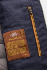 Nahaufnahme der Innenansicht der Moorer Daunenweste 'Calaf' navy meliert mit Label „Finest Down“, Reißverschlusstasche und feinem Leinenstoff.