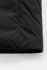 Close-up view of the bottom section of the Canada Goose Daunenweste 'Lodge' schwarz, showing the black ripstop microfiber fabric with a smooth texture and subtle vertical pattern, highlighting the slim fit and stitching details.

<p>Die superleichte Daune