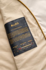 Nahaufnahme der Innenseite der Moorer Outdoor-Weste 'Senio-Si' creme mit schwarzem Label, Sea Island Baumwolle und Seidenmix, glattem Griff, leichter Füllung, slim Fit, schmalem Stehkragen, zwei-Wege-Reißverschluss, schrägen Zipper-Fronttaschen und Innent