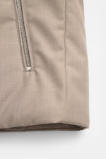 Close-up front view of the taupe fabric and zip pocket of the Moorer Down gilet 'Uros' taupe, made of fine gabardine with water repellent membrane, soft feel, slim fit, two-way zip, standing collar, zip front and inside pockets. For autumn adventures, win