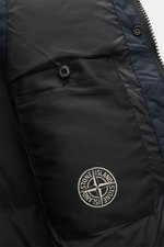 Close-up inside view of Stone Island Daunenweste 'Seamless Tunnel Nylon Down' navy showing black pocket with button and embroidered logo, highlighting high-quality microfiber and smooth lining fabric.