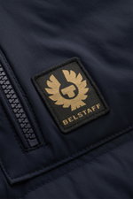 Nahaufnahme der Belstaff Daunenweste 'Chassis' navy, Detailansicht von Reißverschluss und BELSTAFF-Weblabel, glatte Microfaser, Slim Fit, wasserabweisend.