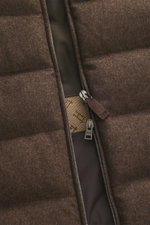 Nahaufnahme der Herno Daunenweste braun meliert von schräg oben, Mix aus Seide und Cashmere, weicher Griff, wärmende Daunenfüllung, Slim Fit, Zwei-Wege-Reißverschluss, Stehkragen, schräge Leistentaschen mit Druckknopf, regulierbare Saumweite, mehrfarbiges