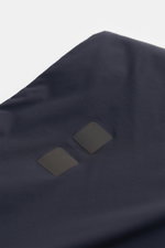UBR Outdoor-Weste 'Raptor' navy aus hochwertiger Microfaser mit leichter Wattierung, reflektierendem Logo-Print, fotografiert aus Nahaufnahme oben.