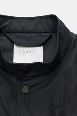 Nahaufnahme des Stehkragens und der Fünf-Knopf-Leiste der 04651/ A trip in a bag Outdoorweste 'Padded Nylon' navy aus glatter Microfaser.