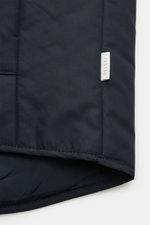 Nahaufnahme der 04651/ A trip in a bag Outdoorweste 'Padded Nylon' navy, Detailansicht des glatten Microfaserstoffs und Label, Slim Fit, Stehkragen.