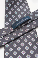 Close-up top view of Bigi Silk tie 'Nilo' dark grey/light blue/white patterned with classic diamond pattern, pure silk, subtle sheen, lining identical to outer fabric, made in Italy, width 8 cm.