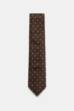 Tom Ford Seidenkrawatte dunkelbraun/creme gepunktet, frontal fotografiert, reine Seide, dezenter Glanz, monochromes Futter, Logo-Stitching, Breite 8 cm, made in Italy.