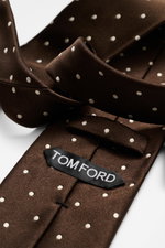 Tom Ford Seidenkrawatte dunkelbraun/creme gepunktet, Nahaufnahme seitlich gefaltet, reine Seide, dezenter Glanz, Logo-Stitching, 8 cm breit, made in Italy.