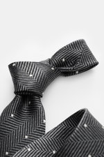 Close-up front-side view of Tom Ford Silk tie dark grey/black/cream patterned, showing herringbone and polka dot details.

<p>Confident elegance down to the finest detail: This fine silk tie by TOM FORD is a stylish essential for your business and evening