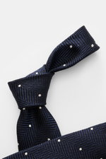 Tom Ford Seidenkrawatte navy/schwarz/creme gemustert mit Fischgratmuster und Punkten, detailreich aus schräger Nahaufnahme, reine Seide, made in Italy.