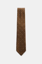 Tom Ford Silk tie light brown/black/cream patterned, shown from top-down view, featuring pure silk, subtle sheen, timeless herringbone with polka dots, logo stitching, made in Italy, 8 cm wide. Confident elegance down to the finest detail: This fine silk 