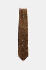 Tom Ford Silk tie light brown/black/cream patterned, shown from top-down view, featuring pure silk, subtle sheen, timeless herringbone with polka dots, logo stitching, made in Italy, 8 cm wide. Confident elegance down to the finest detail: This fine silk 