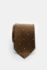 Front-facing close-up of a rolled Tom Ford Silk tie light brown/black/cream patterned, featuring a herringbone design with polka dots and subtle sheen.

<p>Confident elegance down to the finest detail: This fine silk tie by TOM FORD is a stylish essential
