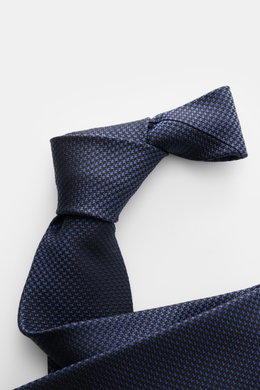 Tom Ford Seidenkrawatte dunkelblau/schwarz gemustert, Hahnentrittmuster, dezenter Glanz, reine Seide, Logo-Stitching, Nahaufnahme von schräger Perspektive.
