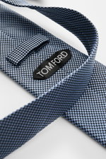Tom Ford Seidenkrawatte hellblau/schwarz gemustert, Hahnentritt, Logo-Stitching, reine Seide, dezenter Glanz, Nahaufnahme von innen mit Label, made in Italy, 8 cm breit.