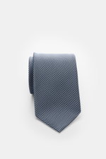 Tom Ford Seidenkrawatte hellblau/schwarz gemustert, Hahnentrittmuster, aus reiner Seide mit dezentem Glanz, Logo-Stitching, seitlich fotografiert, Breite 8 cm.