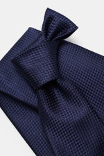 Tom Ford Seidenkrawatte navy gemustert mit Hahnentritt-Webmuster, Logo-Stitching, dezenter Glanz, reine Seide, Breite 8 cm, Aufnahme schräg von oben.