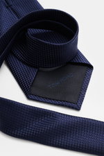 Tom Ford Seidenkrawatte navy gemustert mit Hahnentritt-Webmuster, feiner Glanz, Logo-Stitching, reine Seide, Detailansicht von oben.