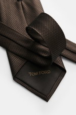 Tom Ford Seidenkrawatte dunkelbraun/schwarz gemustert mit zeitlosem Hahnentritt, aus reiner Seide, mit Logo-Stitching, Detailaufnahme von oben.