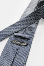 Tom Ford Seidenkrawatte navy/creme gemustert, Detailaufnahme schräg von oben, reine Seide, dezenter Glanz, Logo-Stitching, 8 cm breit, made in Italy.