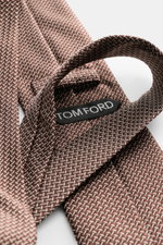 Tom Ford Seidenkrawatte braun/creme gemustert, nah aus schräger Perspektive mit Logo-Stitching, reine Seide, dezenter Glanz, 8 cm breit, made in Italy.
