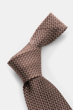 Tom Ford Seidenkrawatte braun/creme gemustert, Detailfoto von oben, raffinierte reine Seide mit dezenter Glanzoptik, grafischem Muster, Logo-Stitching, 8 cm breit, made in Italy.