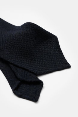 Nahaufnahme der Cesare Attolini Woll-Krawatte 'Sfoderata' navy mit feiner Webstruktur, weichem Griff, reiner Schurwolle, leichter Qualität, Breite 8,5 cm, Made in Italy, fotografiert von schräger Seitenperspektive.