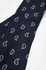 Nahaufnahme der Borrelli Krawatte navy/grau gemustert mit grafischem Muster, handgefertigt aus Seide und Schurwolle, dezenter Glanz, tonaler Futterstoff, Made in Italy, Breite 8 cm, seitliche Perspektive.