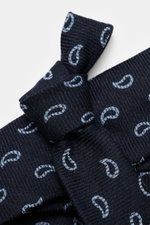 Nahaufnahme der Borrelli Krawatte navy/hellblau gemustert mit grafischem Muster, handgefertigt aus Seide und Schurwolle, dezent glänzend, tonalem Futterstoff, Made in Italy, Breite 8 cm, aus schräger Perspektive.