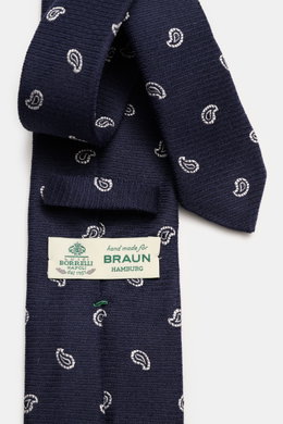 Nahaufnahme der Borrelli Krawatte navy/offwhite gemustert mit grafischem Muster, handgefertigt aus Seide und Schurwolle, dezent glänzend, tonaler Futterstoff, Made in Italy, Breite 8 cm, von oben fotografiert.