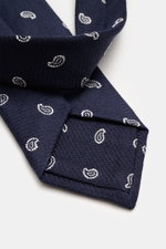 Nahaufnahme der Borrelli Krawatte navy/offwhite gemustert mit grafischem Muster, handgefertigt aus Seide und Schurwolle, dezent glänzend, tonalem Futterstoff, Made in Italy, Breite 8 cm, von oben fotografiert.