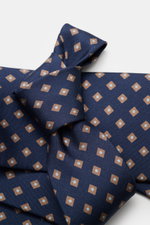 Nahaufnahme der Borrelli Seidenkrawatte navy/hellbraun gemustert mit feinem, grafischem Webmuster, handgefertigt aus reiner Seide, Breite 8 cm, Made in Italy, fotografiert von oben.
