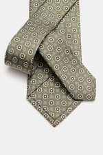 Nahaufnahme der Borrelli Seidenkrawatte grün/braun gemustert mit feinem, floralem Webmuster, reine Seide, Made in Italy, tonaler Futterstoff, Breite 8 cm, aus schräger Perspektive fotografiert.