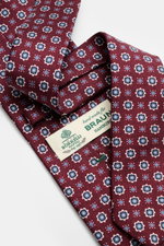 Nahaufnahme der Borrelli Seidenkrawatte bordeaux/graublau gemustert mit feinem floralem Webmuster, handgefertigt in Italien, 8 cm breit, von oben fotografiert.