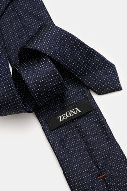Zegna Seidenkrawatte navy/creme gemustert in Nahaufnahme von schräg oben, reine Seide, dezenter Glanz, grafisches Webmuster, kontrastfarbener Futterstoff, Made in Italy, Breite ca. 8 cm.