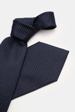 Zegna Seidenkrawatte navy/creme gemustert, Nahaufnahme von oben, reine Seide, dezenter Glanz, grafisches Webmuster, kontrastfarbener Futterstoff, Made in Italy, Breite ca. 8 cm.
