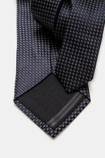 Nahaufnahme der Zegna Krawatte navy/hellgrau/schwarz gemustert mit grafischem Muster, dezenter Glanz, reine Seide, Made in Italy, ca. 8 cm breit, von oben fotografiert.