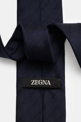 Close-up top-down view of Zegna Tie navy showing fabric texture and label, made of a mix of wool and silk with subtle shine, subtle striped pattern, Made in Italy, width approx. 8 cm.