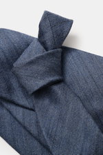 Nahaufnahme der Zegna Krawatte rauchblau mit dezenter Streifenstruktur, fotografiert von oben; Mix aus Wolle und Seide, dezenter Glanz, Made in Italy, Breite ca. 8 cm.
