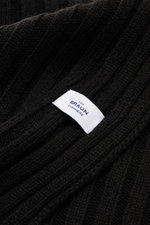 Nahaufnahme des von Braun Cashmere Schals schwarz in klassischem Rippstrick-Design mit feinem Strickbild und weißem Markenlabel, weicher Griff.