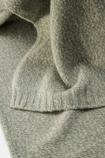 04651/ A trip in a bag Schal 'Mouline Scarf' salbei/hellgrau meliert, Nahaufnahme aus schräger Perspektive, weicher Woll-Cashmere-Mix, Rippstrick-Kanten, ca. 170 x 34 cm, stilvoll und komfortabel im Winter.