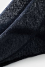 Nahaufnahme des Fedeli Cashmere Tuchs 'Yeti' navy mit geflammter Optik und offenem Saum, weich und voluminös aus reiner Cashmere, seitlich fotografiert.